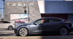 Tesla Delivery Announcement Propels Shares Upward, Ignites Wall Street Debate